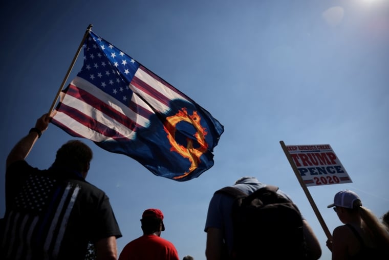 A supporter of President Donald Trump holds an U.S. flag with a reference to QAnon during a Trump 2020 Labor Day cruise rally in honor of Patriot Prayer supporter Aaron J. Danielson, who was shot dead in Portland, Oregon, after street clashes between supporters of President Donald Trump and counter-demonstrators, in Oregon city, Oregon, U.S. September 7, 2020. REUTERS/Carlos Barria